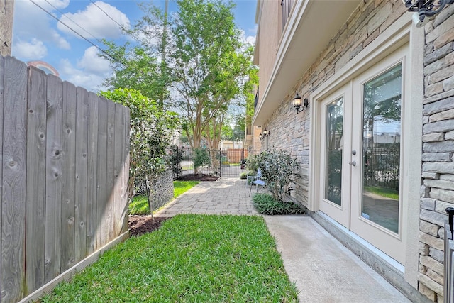 view of yard with a patio, fence, and french doors