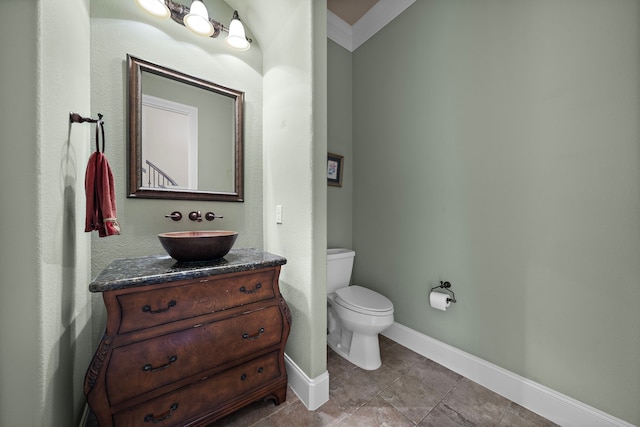 half bathroom with vanity, toilet, baseboards, and tile patterned flooring