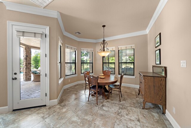 dining room featuring baseboards, ornamental molding, plenty of natural light, and light stone finish flooring