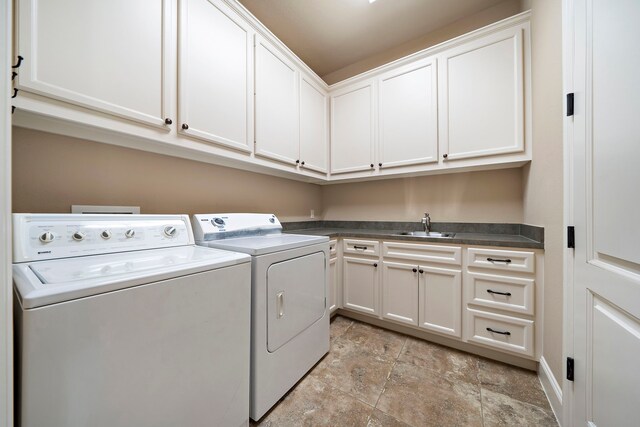 clothes washing area with cabinet space, washer and dryer, and stone finish floors
