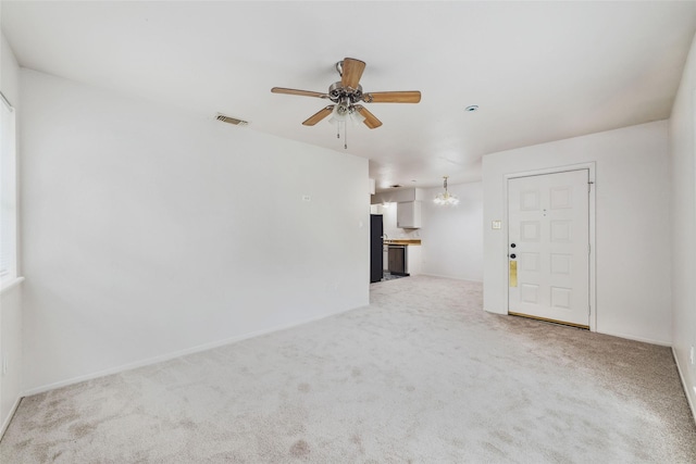 unfurnished living room with ceiling fan with notable chandelier, light colored carpet, and visible vents