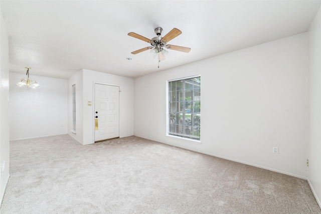 carpeted empty room featuring baseboards and a ceiling fan