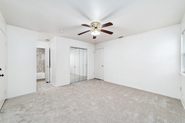 unfurnished bedroom with baseboards, ensuite bathroom, carpet flooring, and visible vents