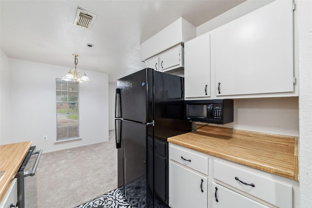 kitchen featuring visible vents, black microwave, a notable chandelier, carpet flooring, and white cabinetry