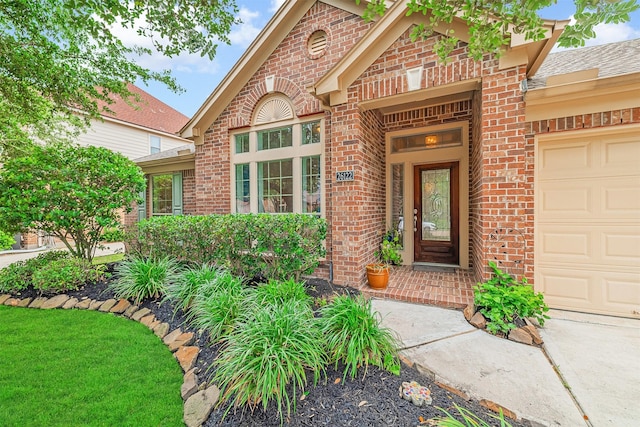 entrance to property with brick siding and a garage