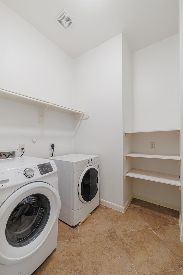 washroom with visible vents, laundry area, baseboards, and washer and dryer