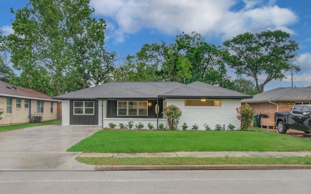 view of front of home with central AC unit, concrete driveway, and a front lawn