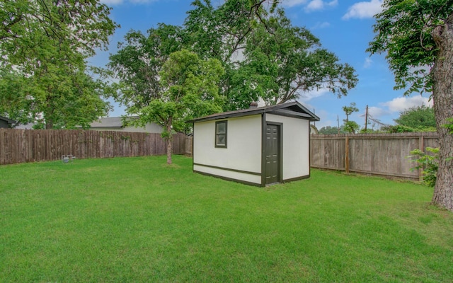 view of yard with a fenced backyard, an outbuilding, and a shed