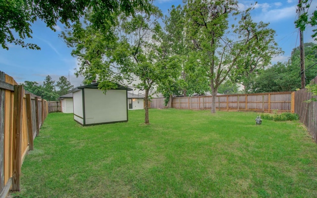 view of yard featuring a fenced backyard and an outbuilding