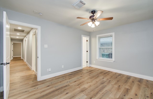 unfurnished room with baseboards, visible vents, ceiling fan, and light wood-type flooring