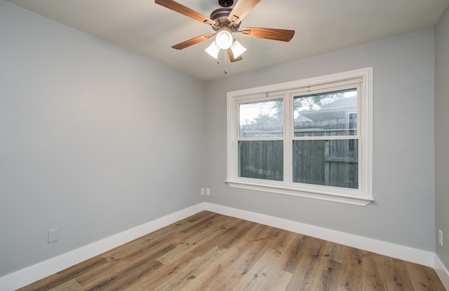 unfurnished room featuring a ceiling fan, baseboards, and wood finished floors