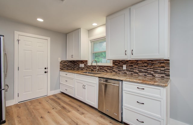 kitchen with a sink, decorative backsplash, appliances with stainless steel finishes, and white cabinets
