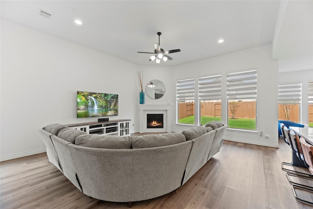 2122 Rosybill Dr, Katy, TX 77494 - living room featuring a ceiling fan, a lit fireplace, visible vents, wood finished floors, and baseboards