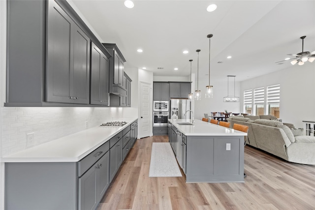 2122 Rosybill Dr, Katy, TX 77494 - kitchen with appliances with stainless steel finishes, a sink, gray cabinets, light wood-style flooring, and open floor plan