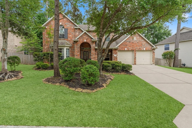 traditional-style home featuring fence, a front lawn, brick siding, a garage, and concrete driveway