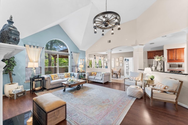 living room featuring ornate columns, wood finished floors, visible vents, and high vaulted ceiling