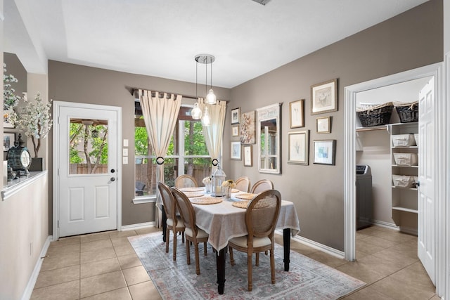 dining area with light tile patterned floors, baseboards, and a notable chandelier