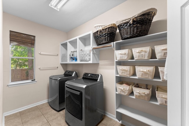 washroom with separate washer and dryer, laundry area, baseboards, and tile patterned floors