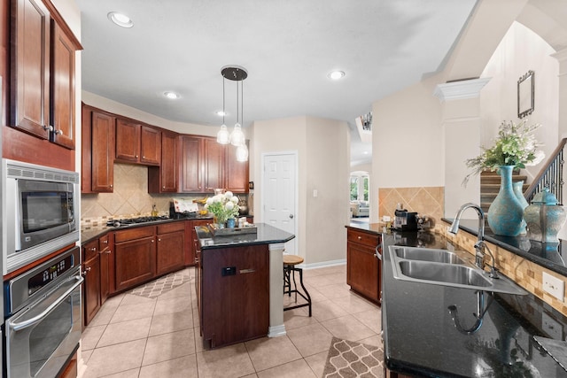 kitchen featuring a sink, decorative backsplash, a kitchen bar, and stainless steel appliances