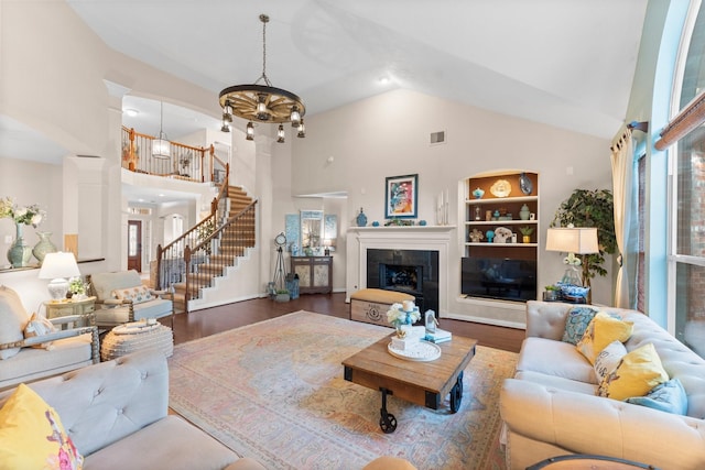 living area featuring high vaulted ceiling, plenty of natural light, built in features, and wood finished floors