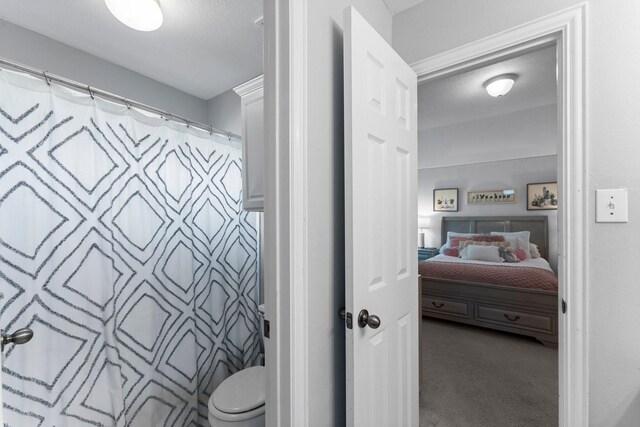 full bathroom with connected bathroom, curtained shower, and toilet