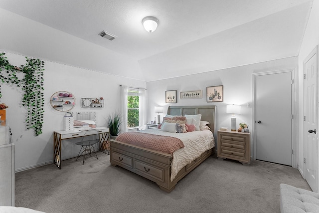 carpeted bedroom featuring visible vents and vaulted ceiling