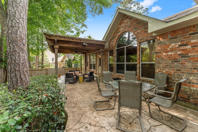 view of patio / terrace with an outdoor living space, ceiling fan, fence, and outdoor dining space