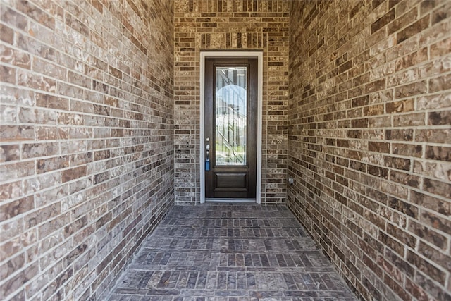 view of exterior entry with brick siding