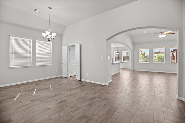 interior space with arched walkways, vaulted ceiling, wood finished floors, and visible vents