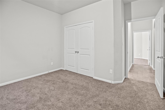 unfurnished bedroom with baseboards, carpet, and a closet