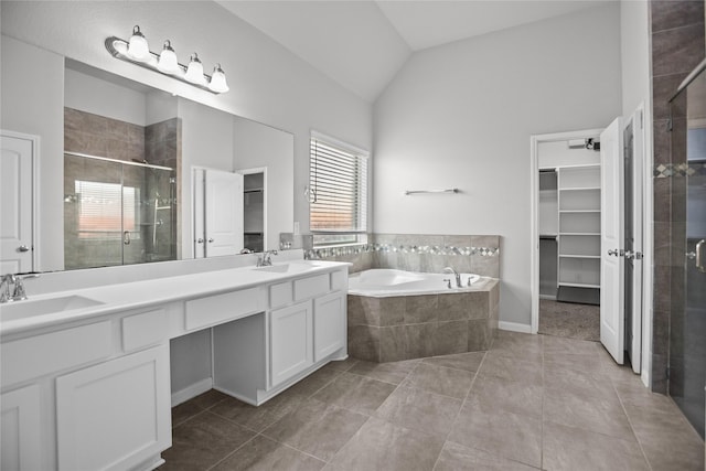 full bathroom featuring double vanity, a garden tub, vaulted ceiling, a shower stall, and a sink