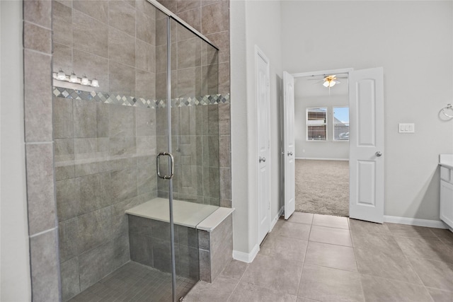 bathroom with baseboards, a ceiling fan, tile patterned floors, and a shower stall