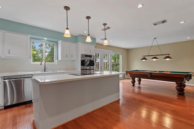 kitchen featuring light countertops, stainless steel appliances, visible vents, and a sink
