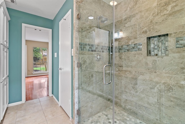 full bathroom featuring tile patterned flooring, baseboards, and a stall shower