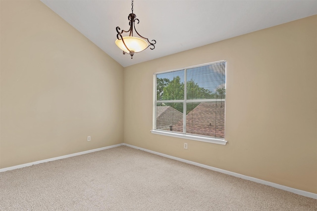 spare room with carpet floors, baseboards, and vaulted ceiling
