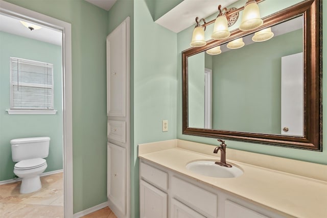 bathroom featuring vanity, baseboards, and toilet