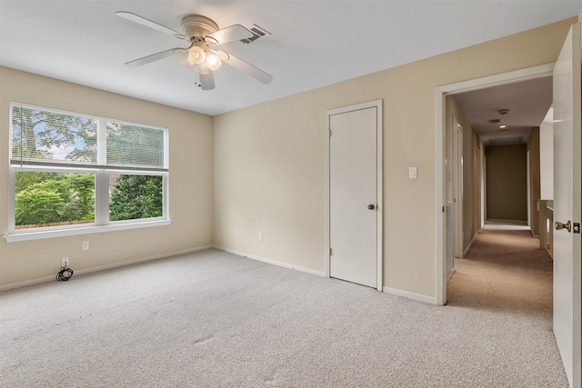 carpeted empty room featuring baseboards, visible vents, and ceiling fan