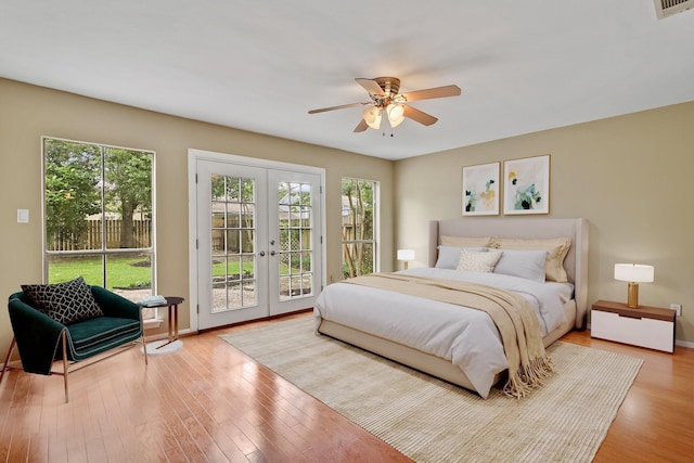 bedroom featuring french doors, visible vents, access to exterior, wood finished floors, and baseboards