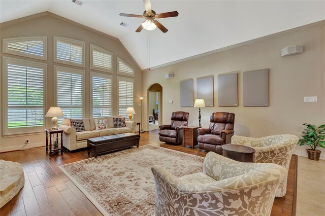 living area featuring arched walkways, plenty of natural light, a ceiling fan, and lofted ceiling