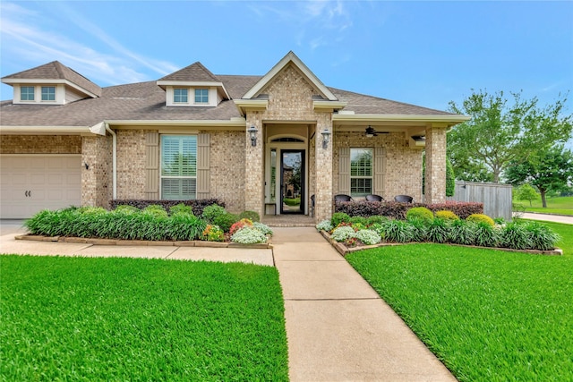 view of front of house featuring roof with shingles, a front lawn, and brick siding