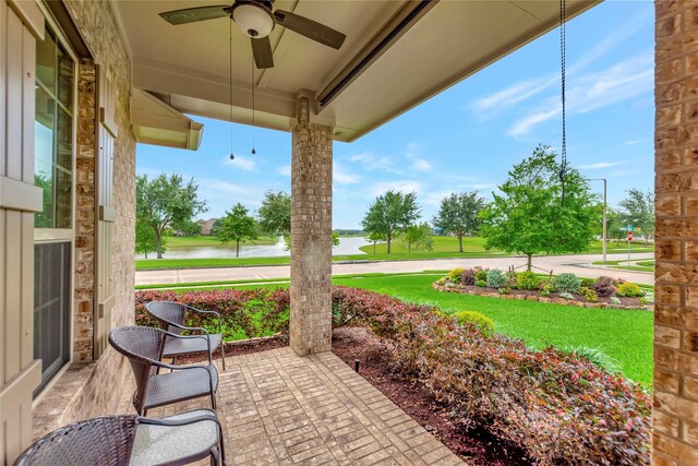 view of patio / terrace with a ceiling fan and a water view