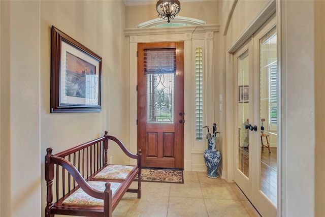 foyer entrance with light tile patterned floors, plenty of natural light, and french doors