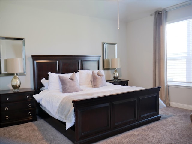 bedroom featuring baseboards and light colored carpet