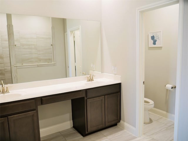 bathroom featuring a sink, toilet, and double vanity