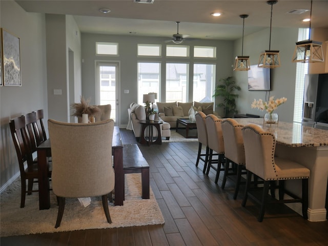 dining space with a ceiling fan, baseboards, visible vents, and dark wood-type flooring
