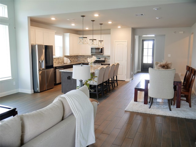 living room featuring baseboards, visible vents, recessed lighting, and dark wood-type flooring
