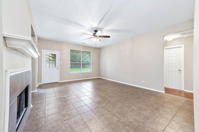 unfurnished living room with ceiling fan, a fireplace, baseboards, and light tile patterned floors