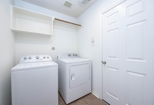 laundry area featuring washing machine and clothes dryer and tile patterned flooring