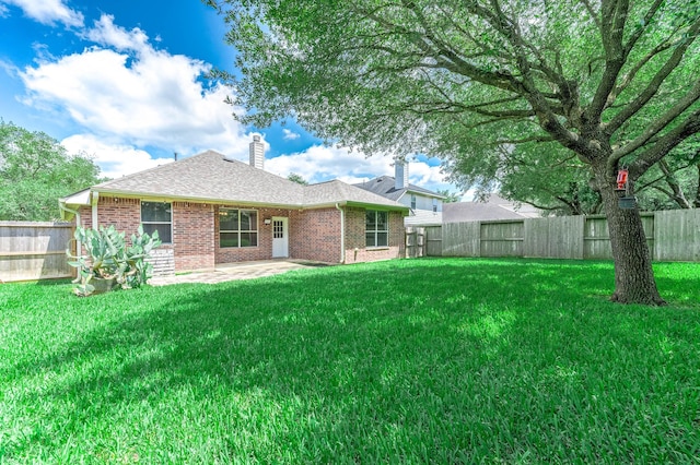back of property with brick siding, a chimney, a patio, and a shingled roof
