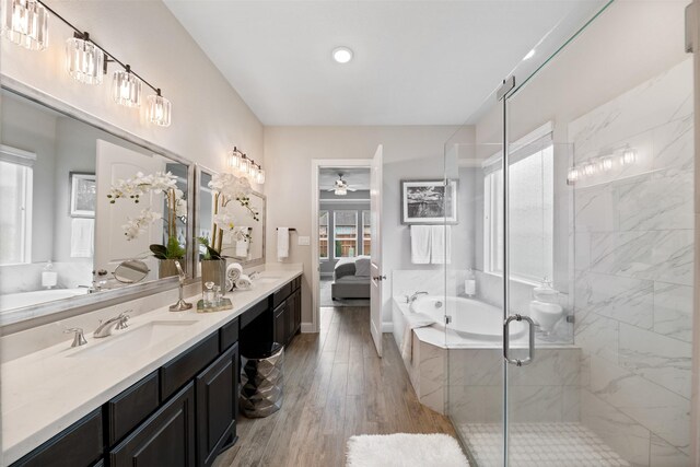 bathroom with double vanity, ceiling fan, a sink, and a stall shower